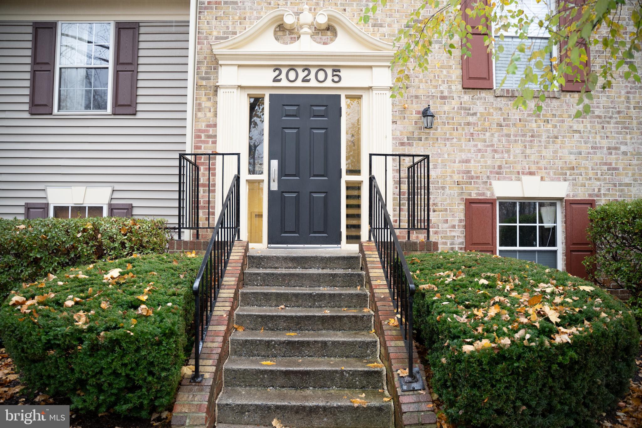 a front view of a house with a garden and plants