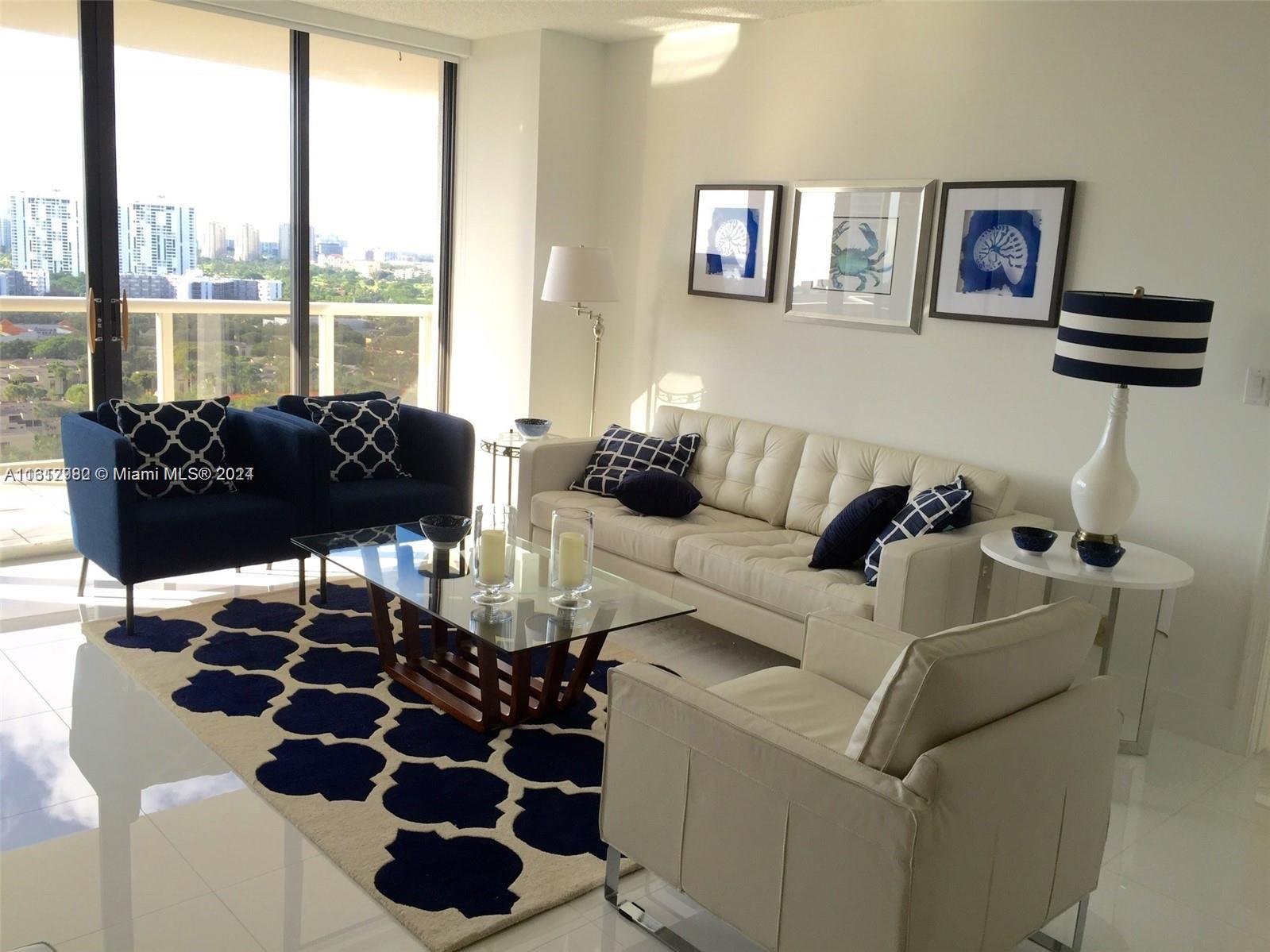 a living room with furniture and a floor to ceiling window