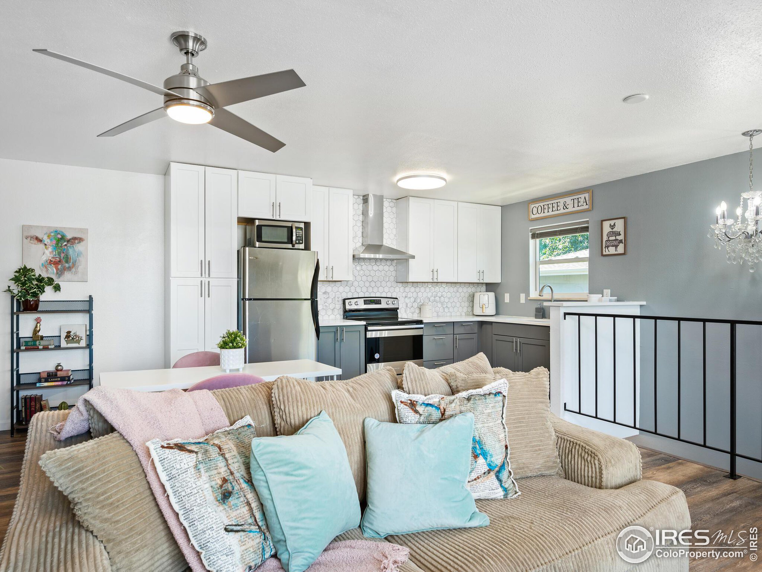 a living room with furniture a large window and kitchen view