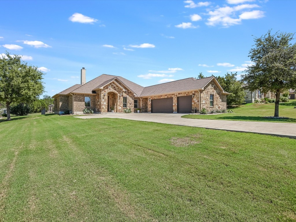 a view of a house with a big yard and large trees