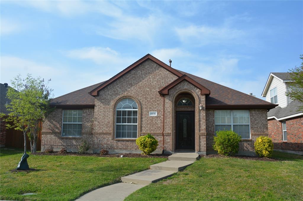 a front view of a house with a garden and yard