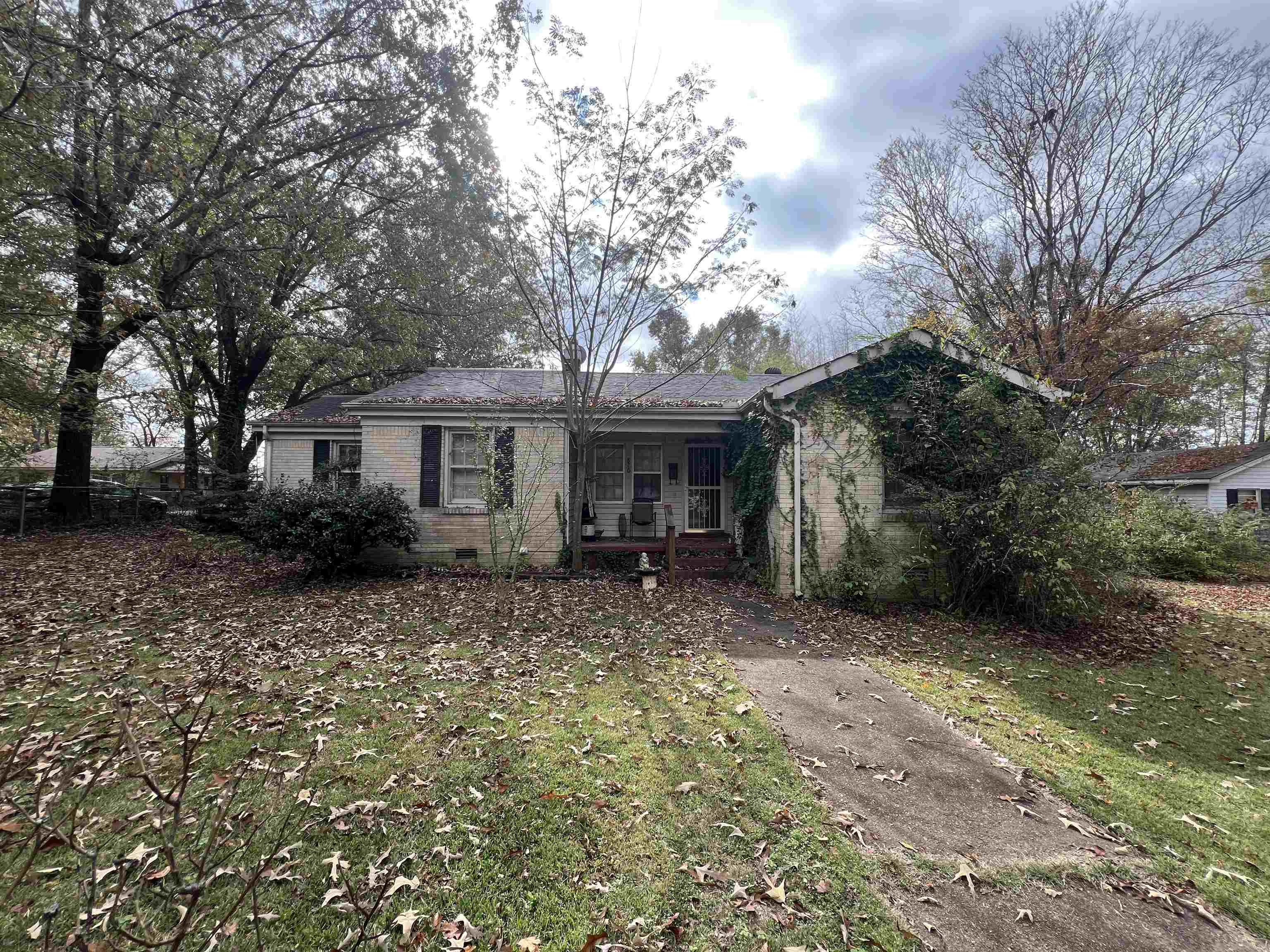 Rear view of house featuring covered porch and a yard