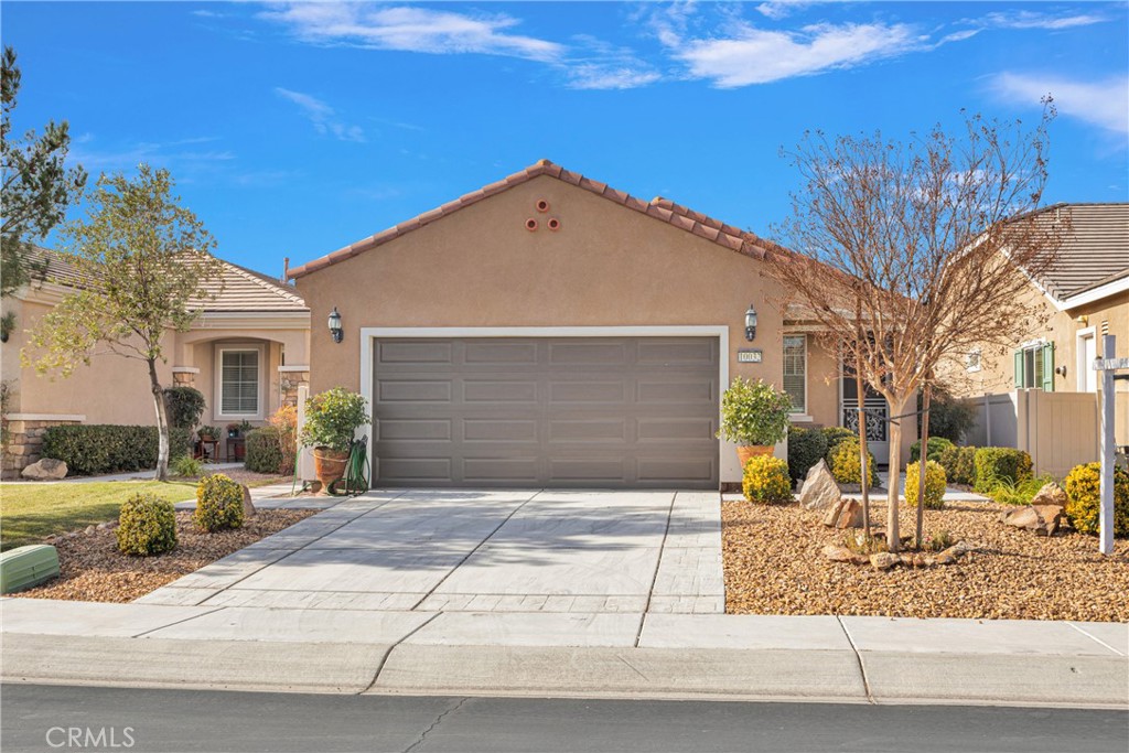 a front view of a house with a yard and potted plants