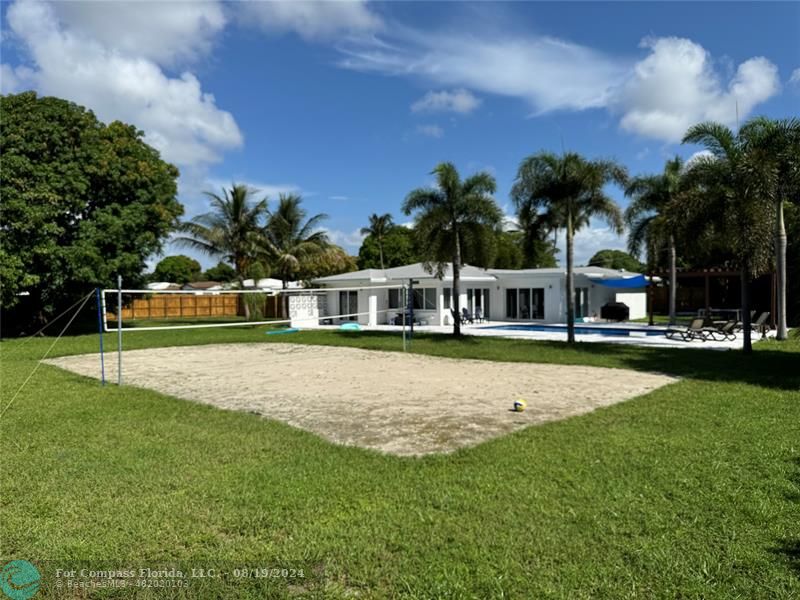 a front view of a house with a garden and swimming pool