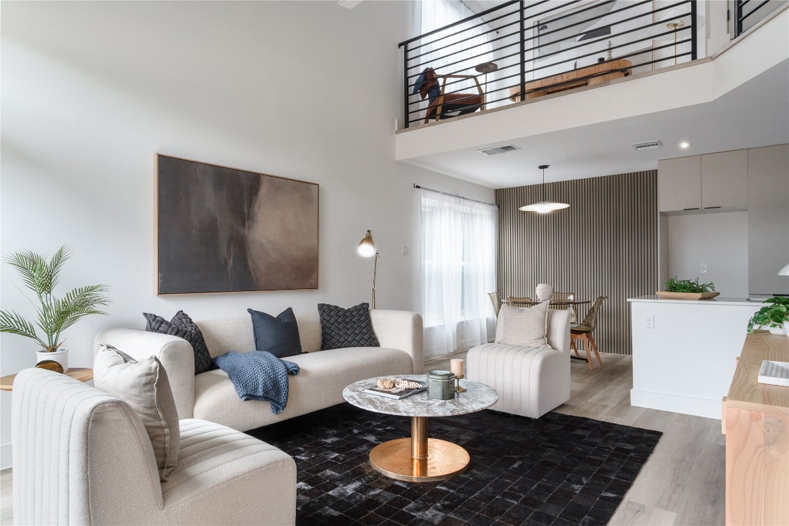 a living room with furniture and a dining table with wooden floor