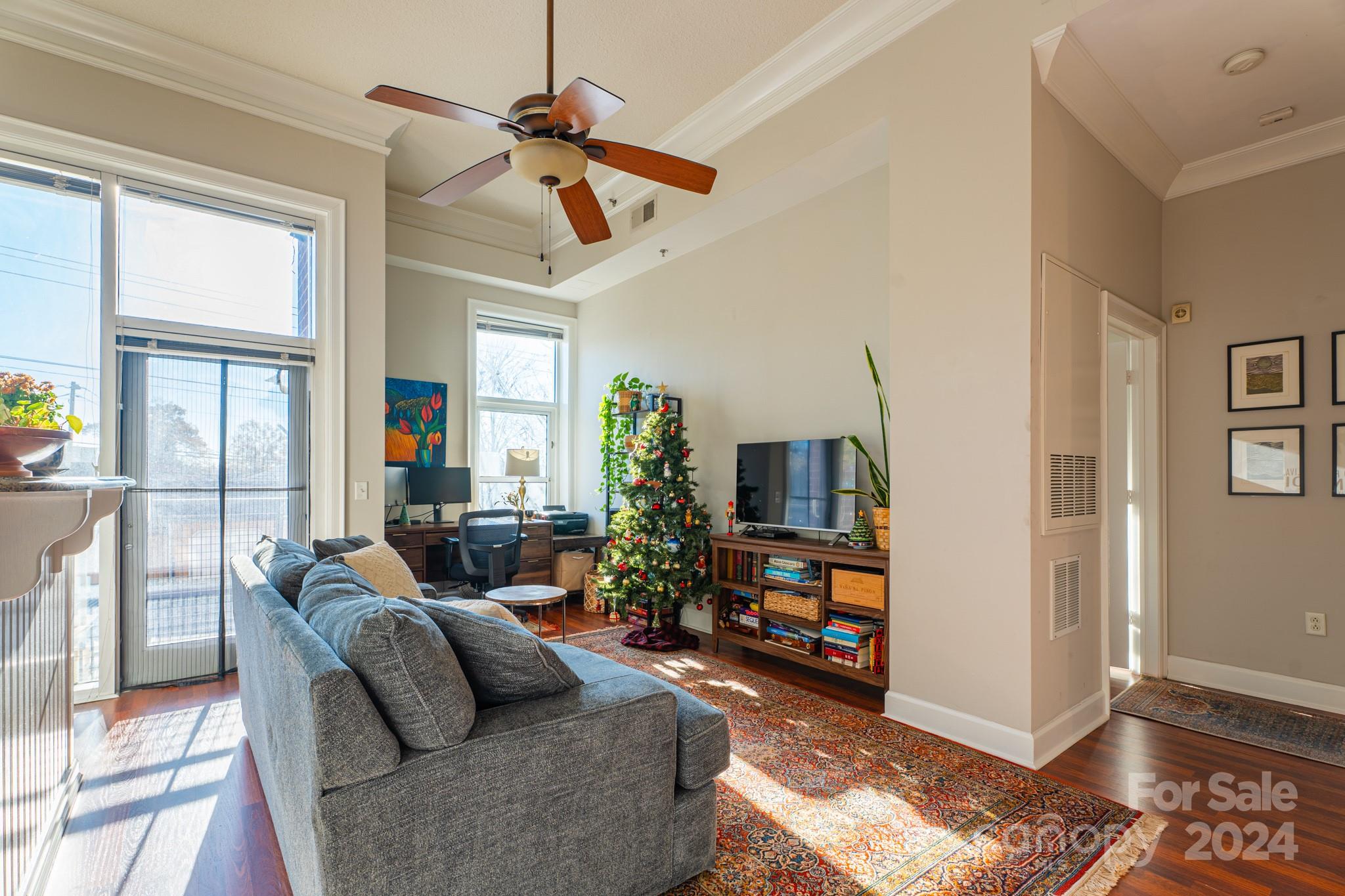 a living room with furniture a flat screen tv and a window