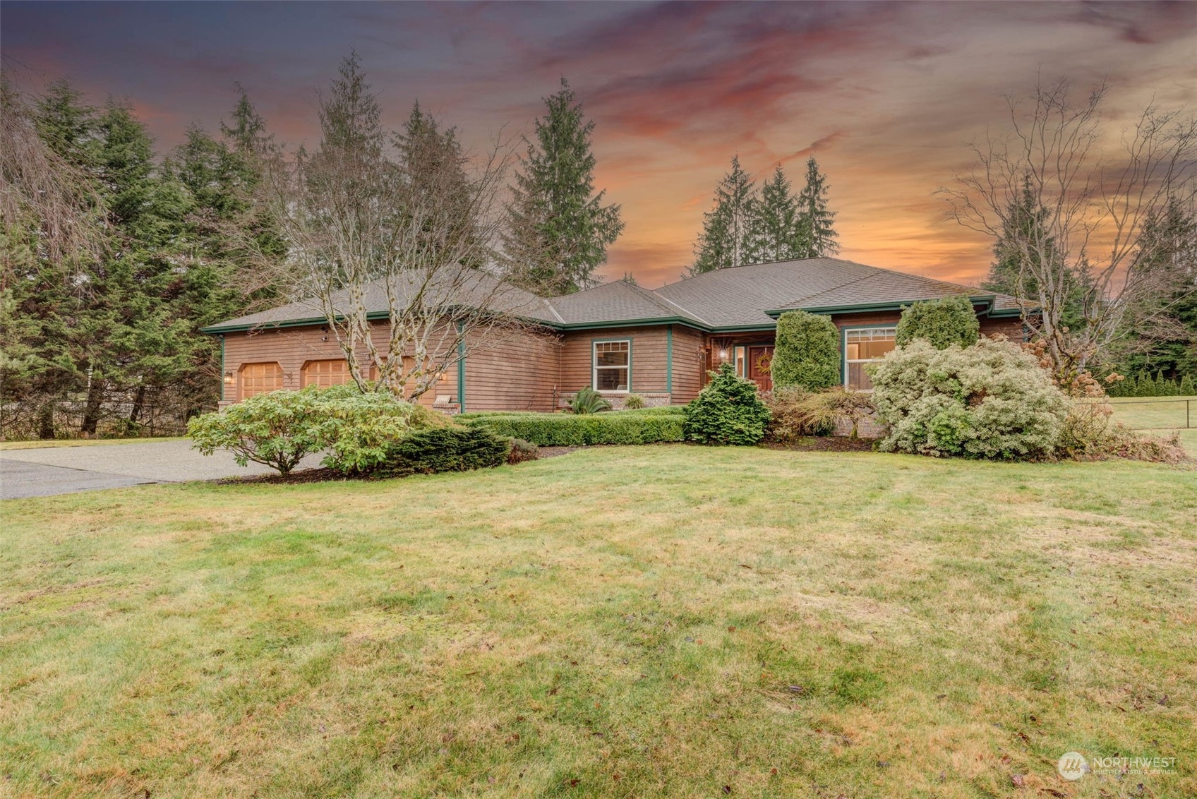 a front view of house with yard and trees in the background