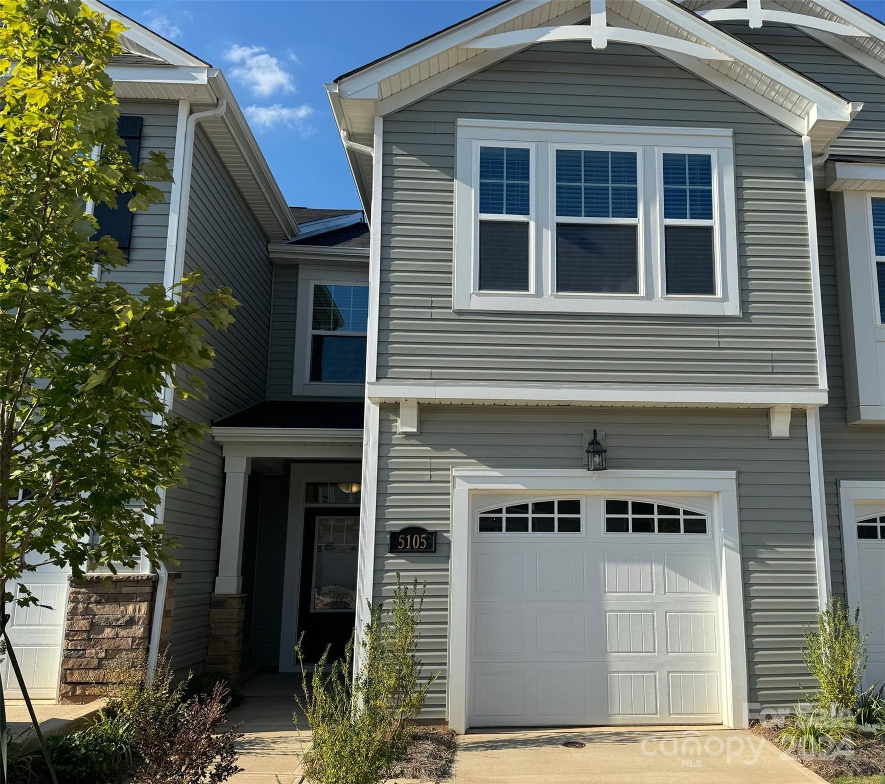 a front view of a house with plants