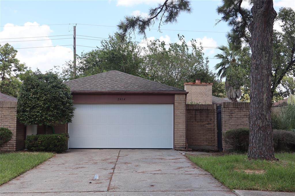 a front view of a house with a garden and tree