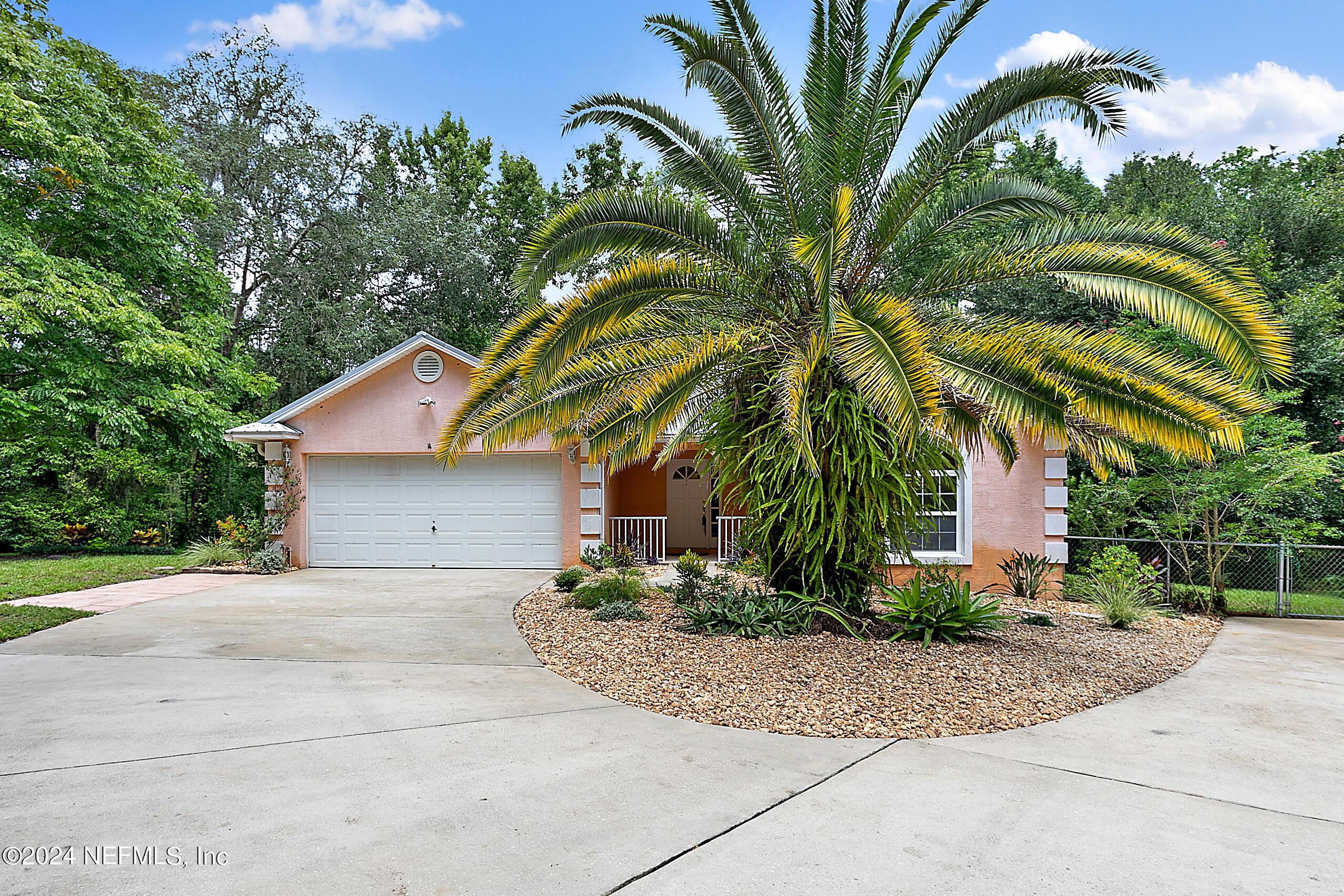 a front view of a house with a yard and trees