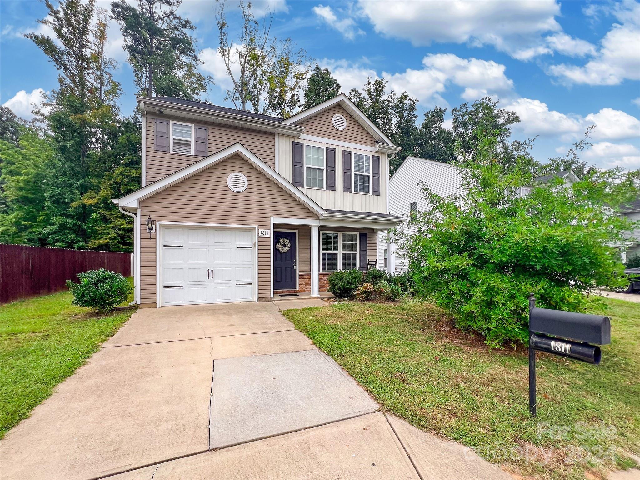 a front view of a house with a yard and trees