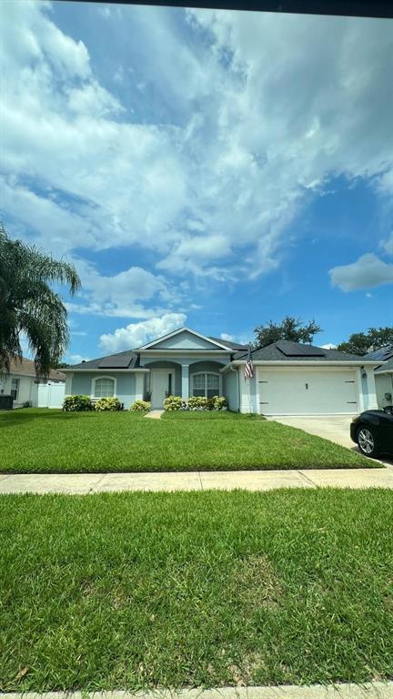 a view of a big house with a big yard and a large tree