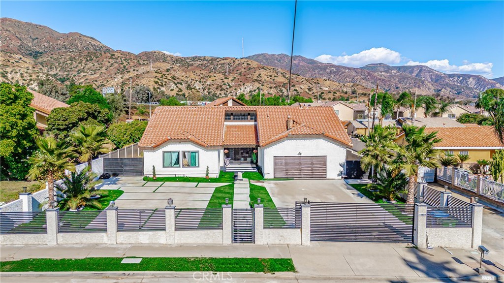 a front view of a house with a yard and mountain view