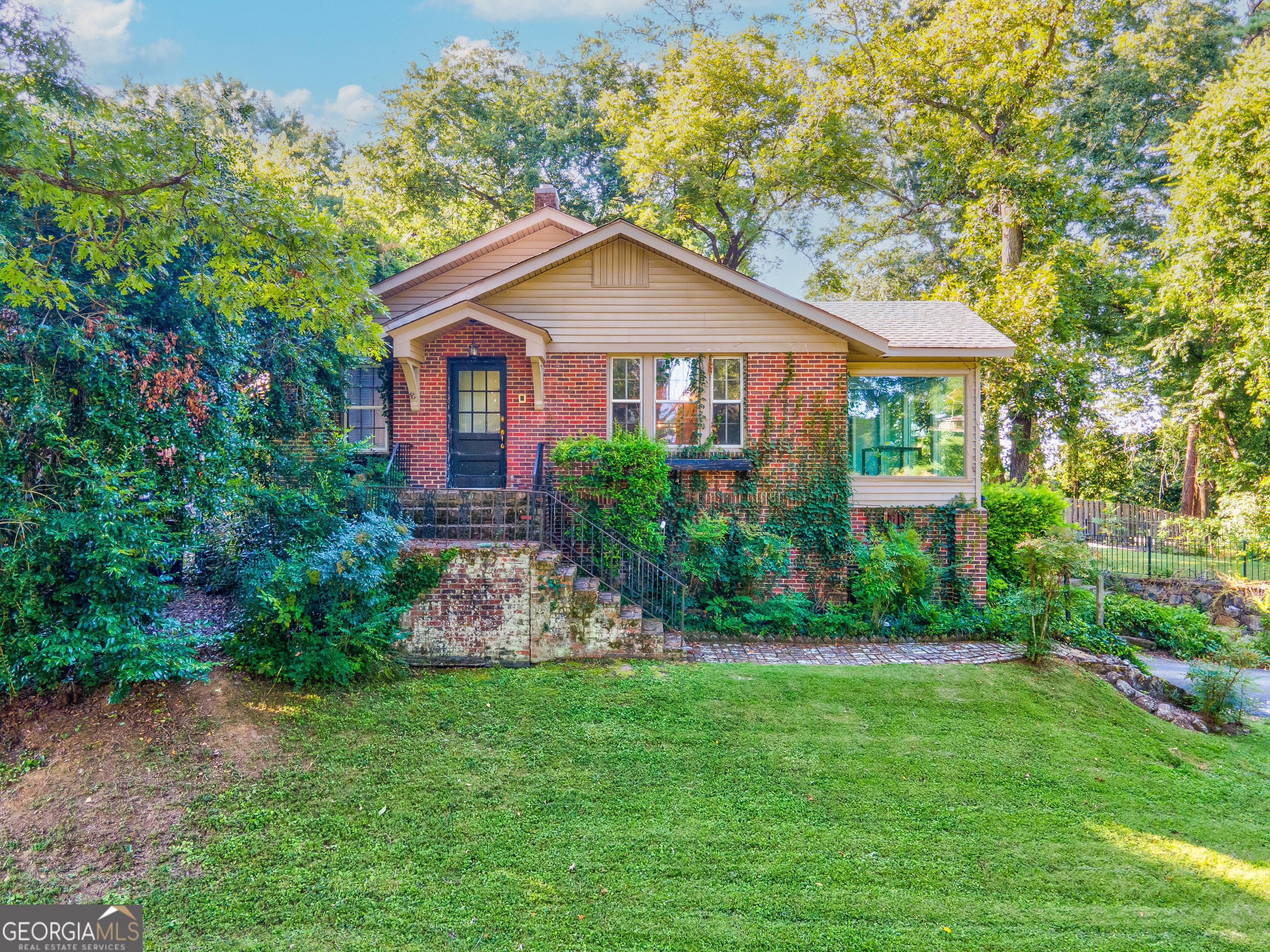 a front view of a house with a yard and garden