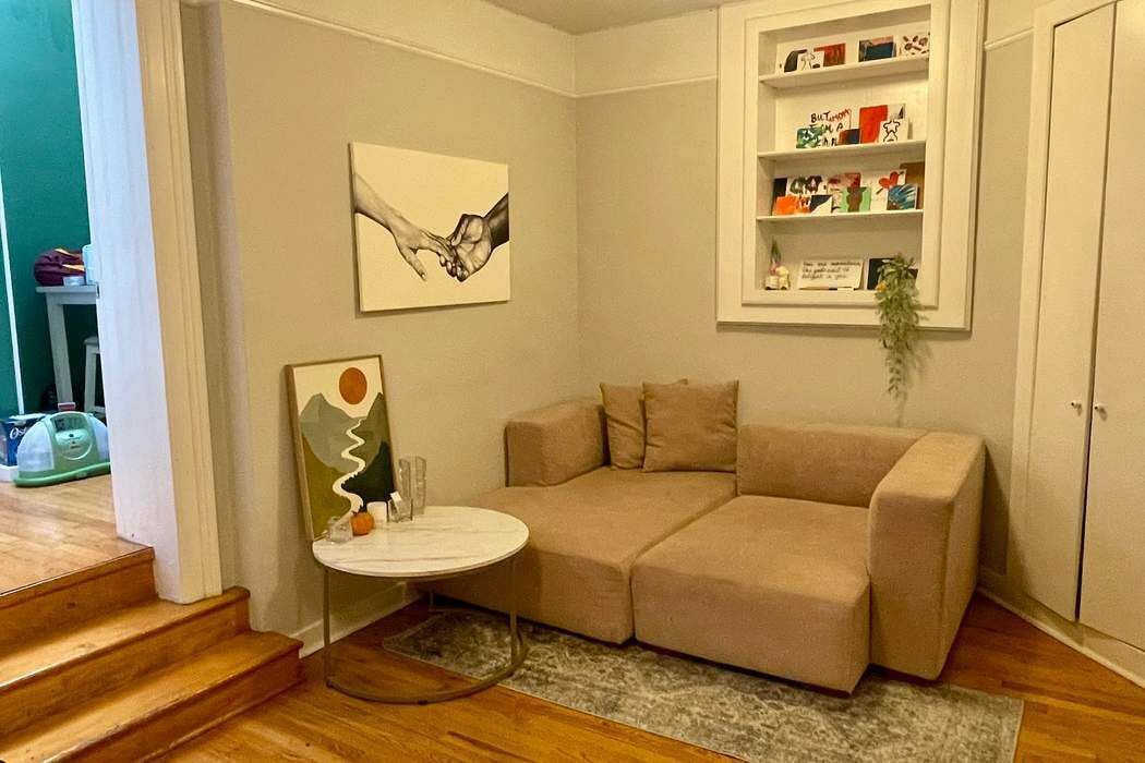 a living room with furniture and a painting on the wall