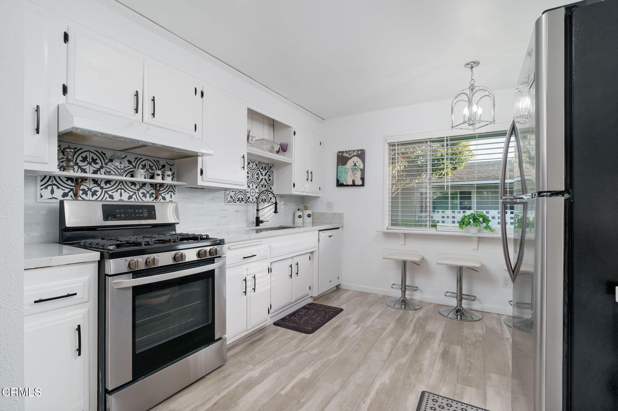 a kitchen with stainless steel appliances a stove a sink and a refrigerator