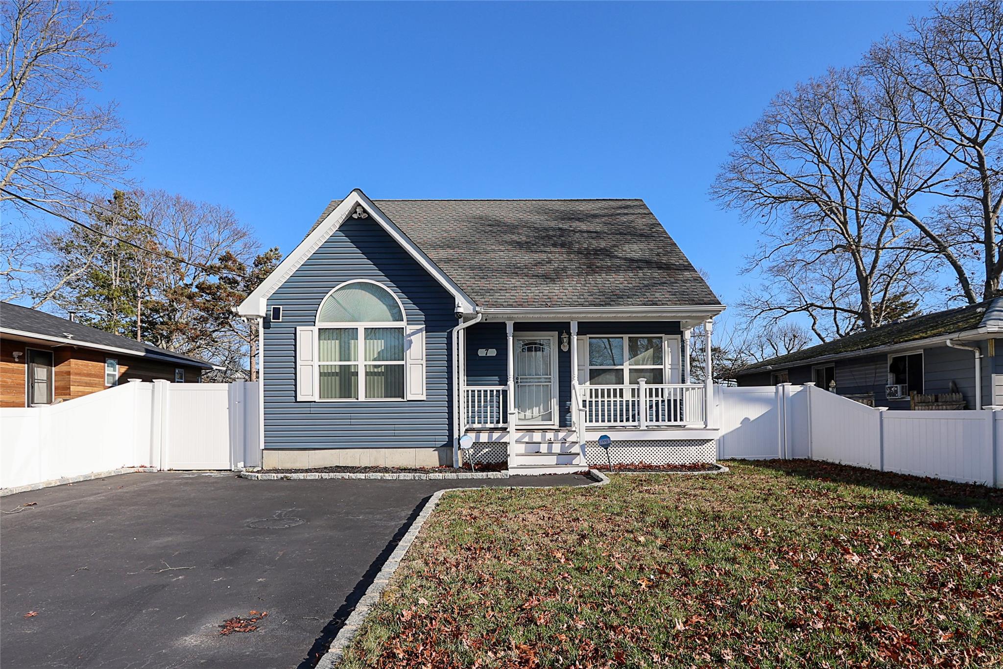 View of front facade featuring covered porch and a front lawn