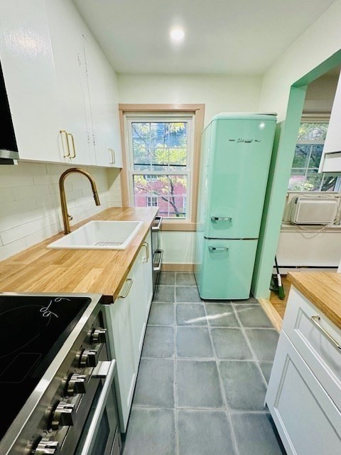 a large kitchen with kitchen island a stove a sink dishwasher and wooden cabinets with wooden floor