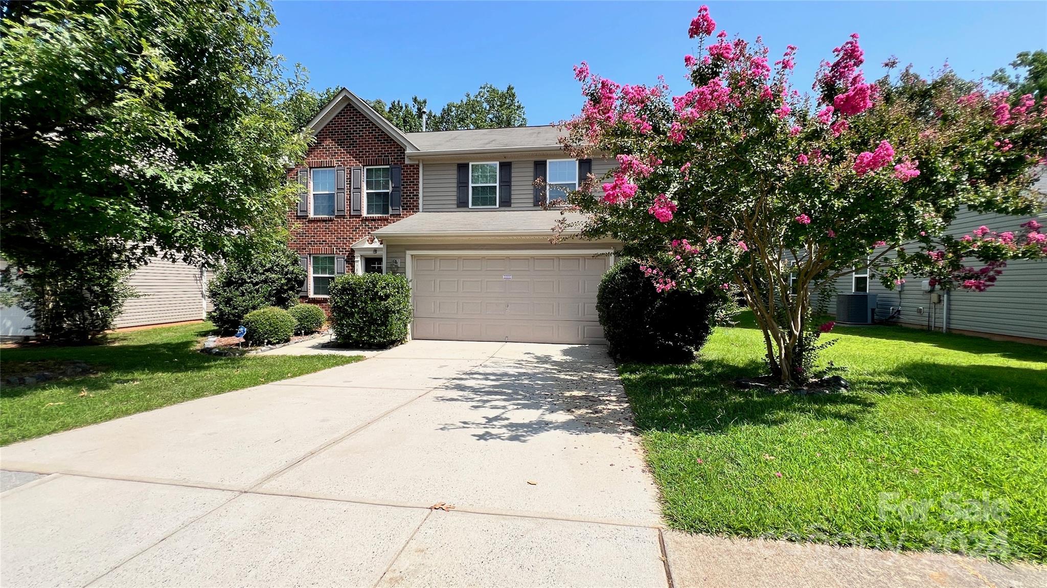 a front view of a house with a yard and a garage