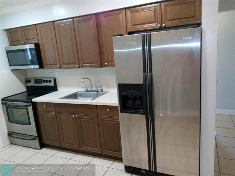 a kitchen with stainless steel appliances granite countertop a refrigerator and a sink