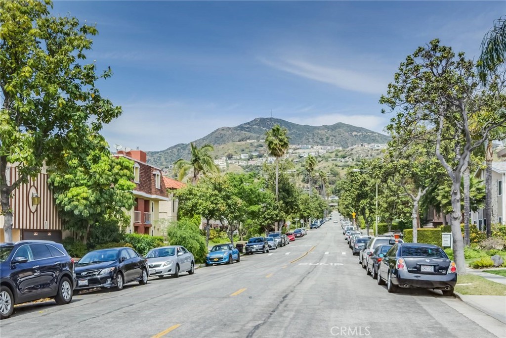 a view of car parked on the side of a street