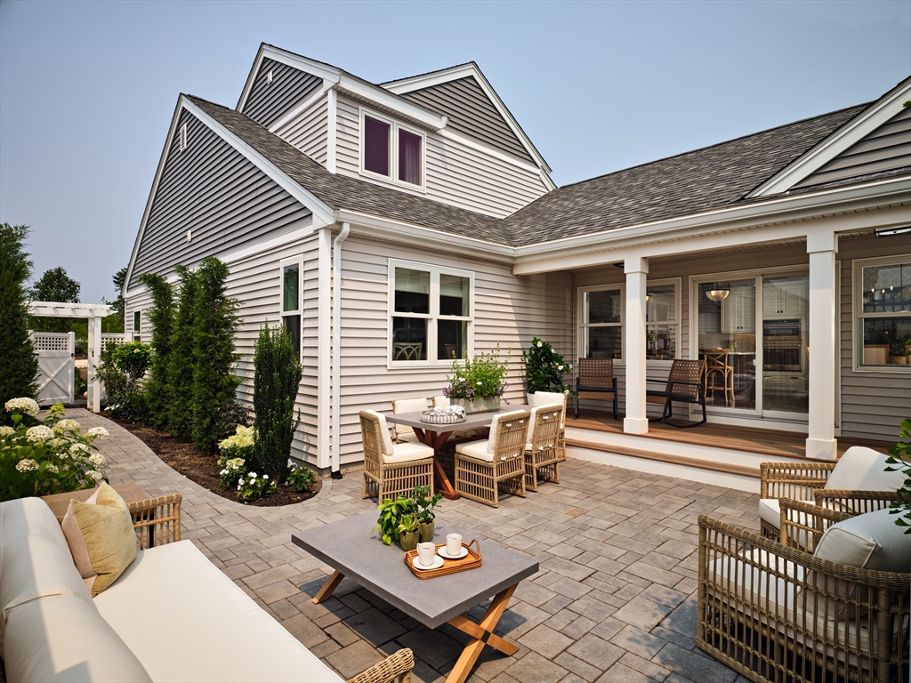 a view of a patio with couches table and chairs and potted plants