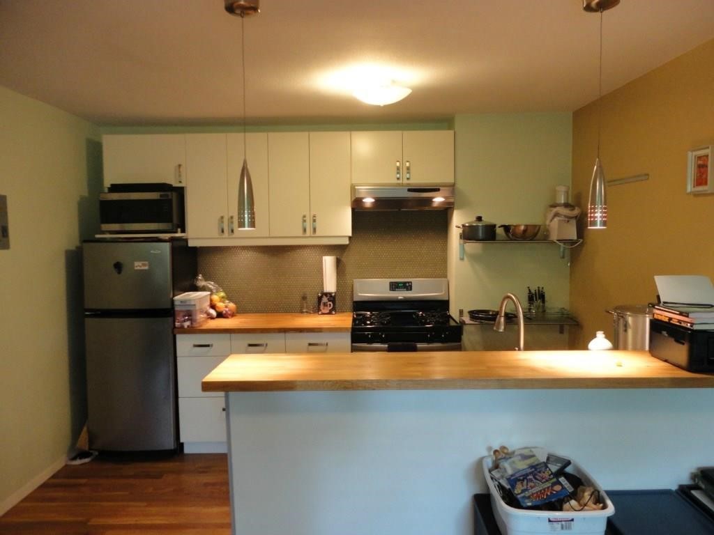 a kitchen with a refrigerator and a stove top oven