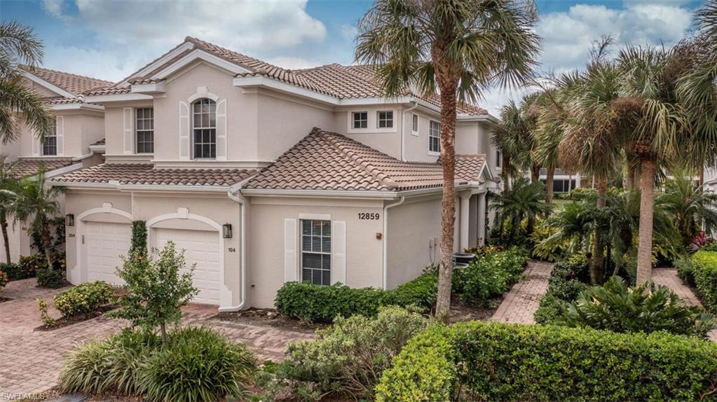 a front view of a house with a yard and palm trees