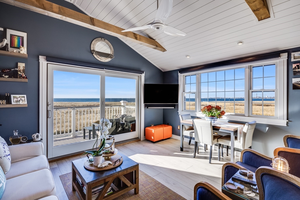 a living room with furniture a flat screen tv and a large window