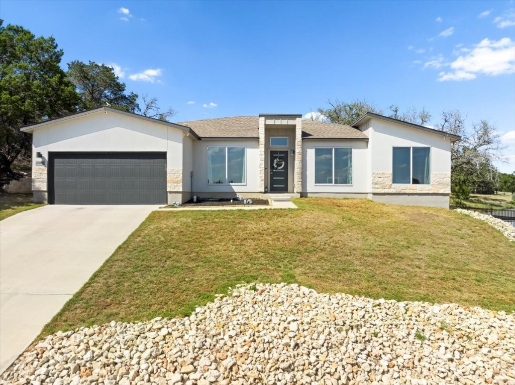 a front view of a house with a garden and yard