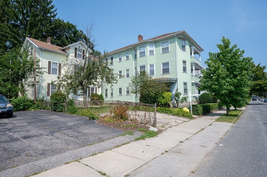 a view of a big house with a yard and plants