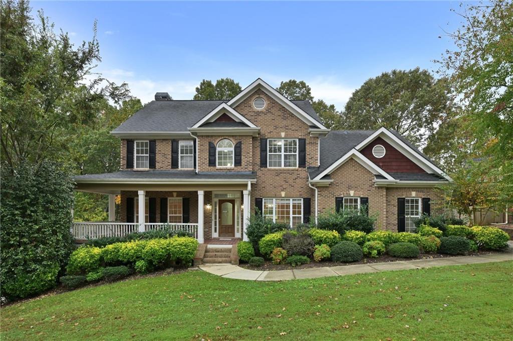 a front view of a house with a yard and potted plants