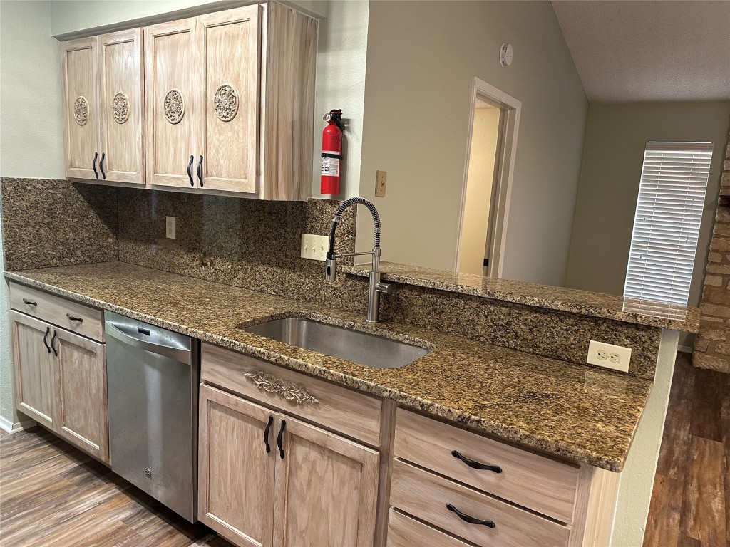 a kitchen with granite countertop a sink and a stove