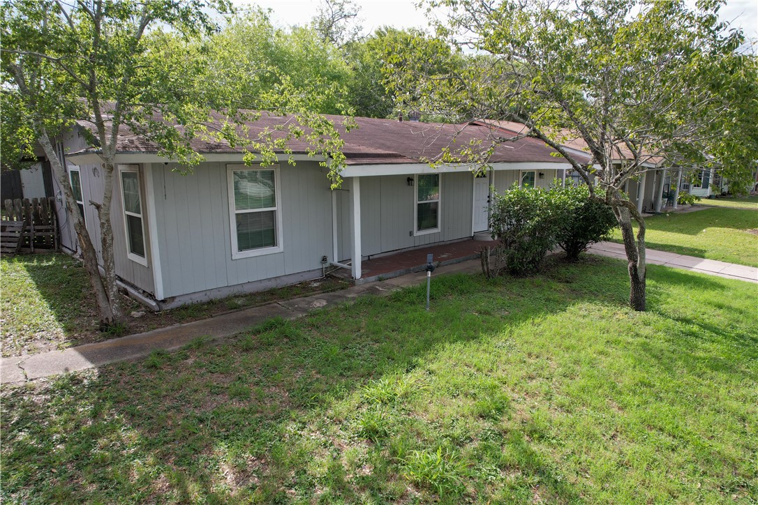 a view of a house with a yard and tree s