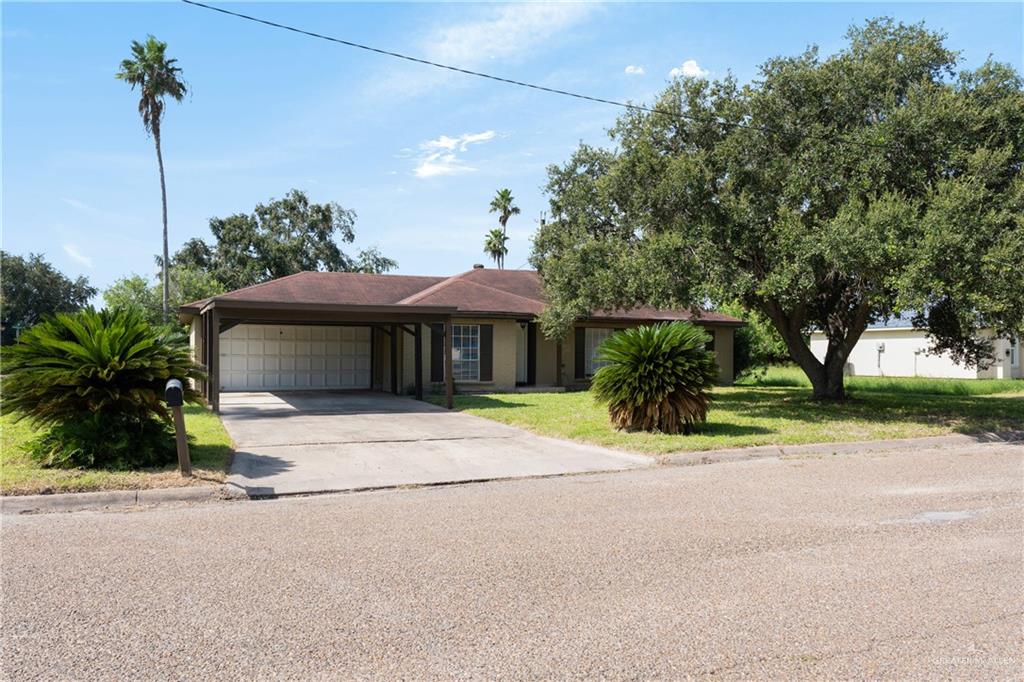 a front view of a house with a yard and a garage