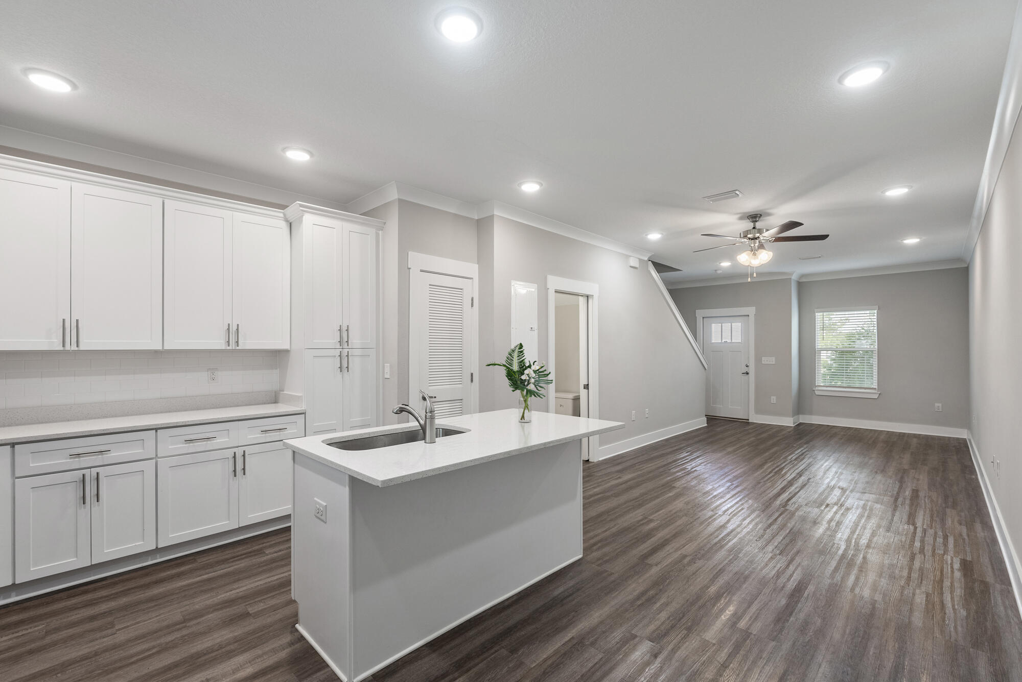 a kitchen with a sink cabinets and wooden floor