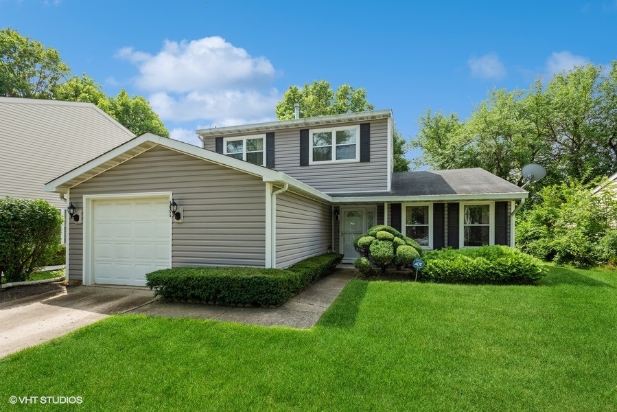 a front view of a house with a garden and plants