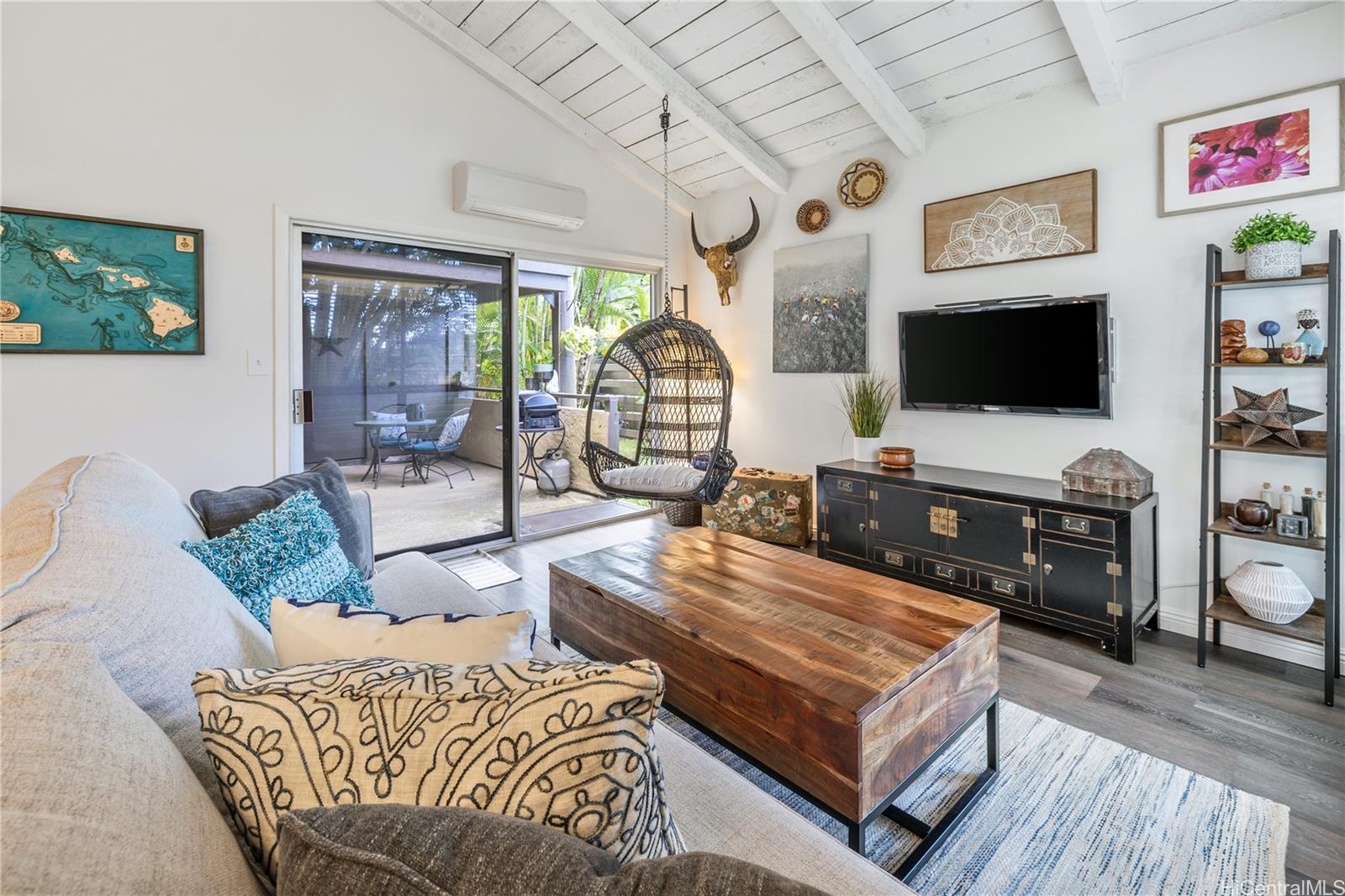 a living room with furniture a flat screen tv and a floor to ceiling window