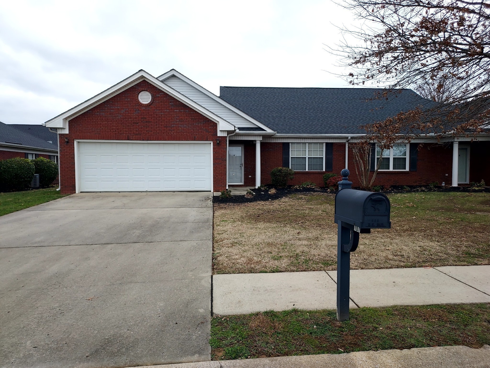 a front view of house with yard and trees in the background