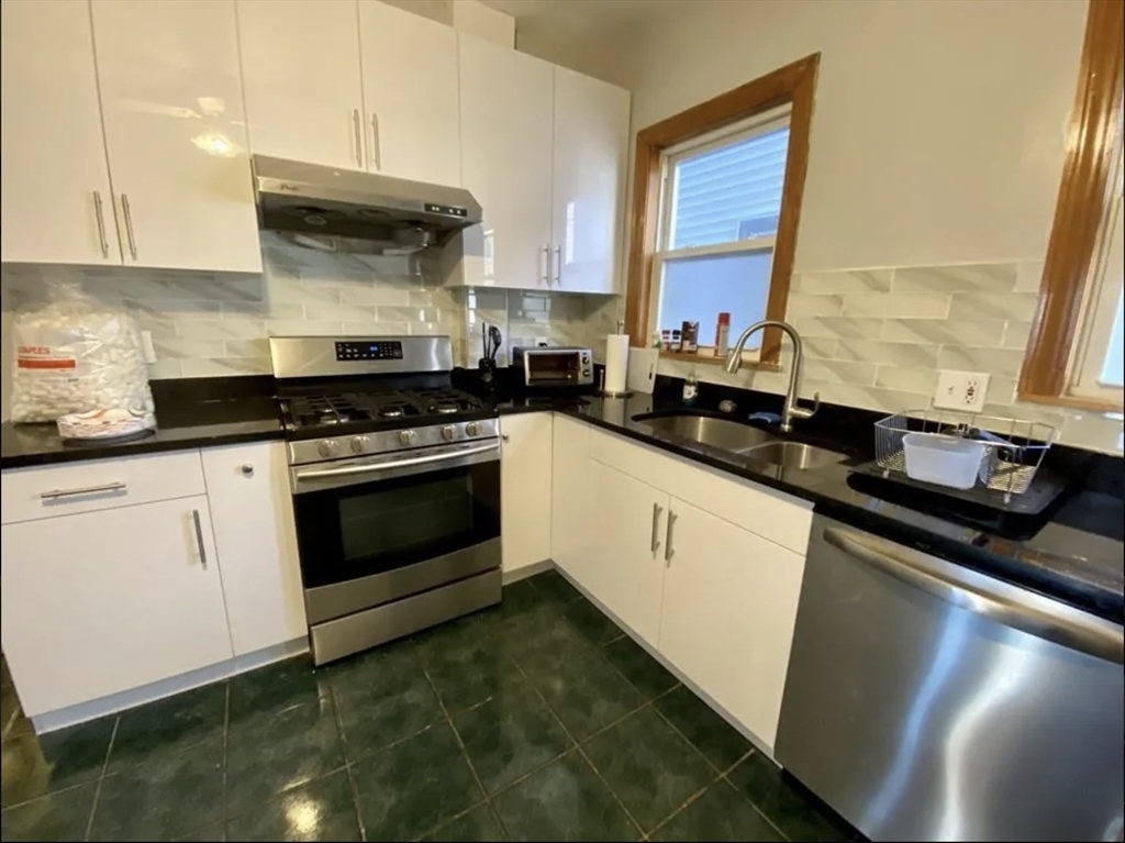 a kitchen with a sink stove top oven and cabinets