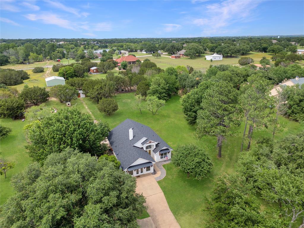 an aerial view of residential houses with outdoor space and trees