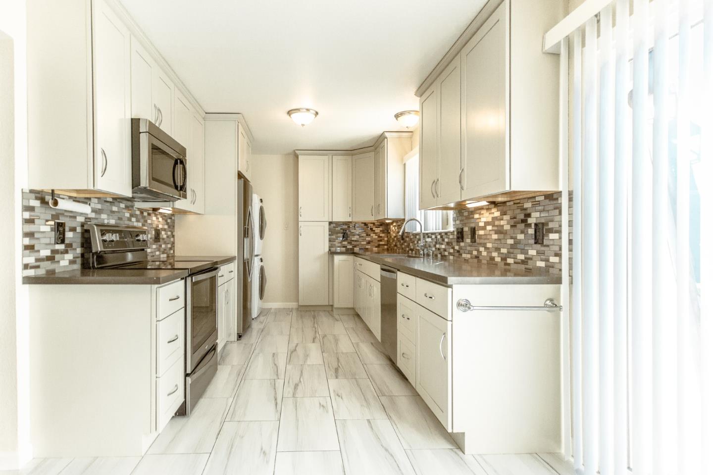 a kitchen with stainless steel appliances a sink stove and cabinets