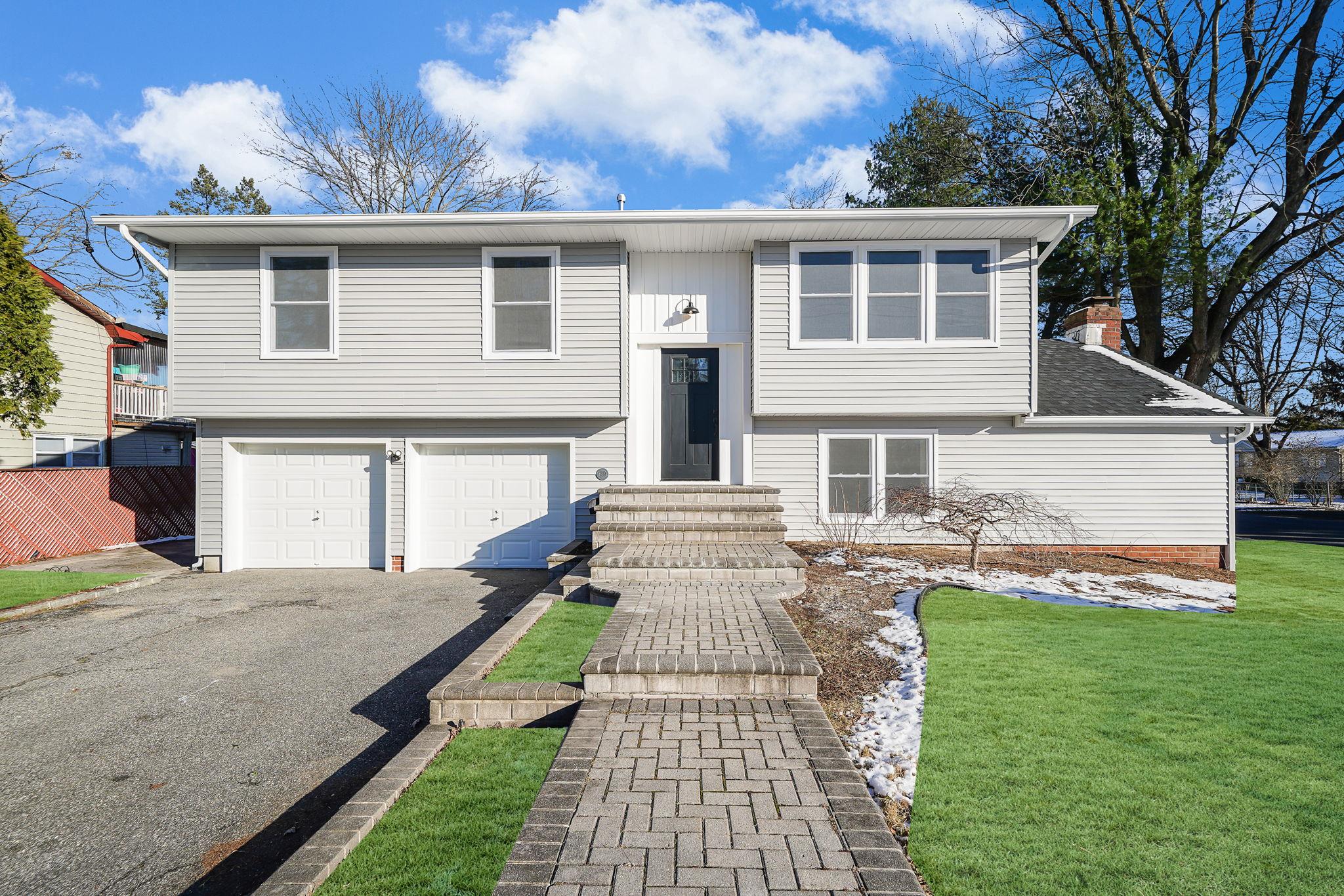 Split foyer home with a front lawn and a garage