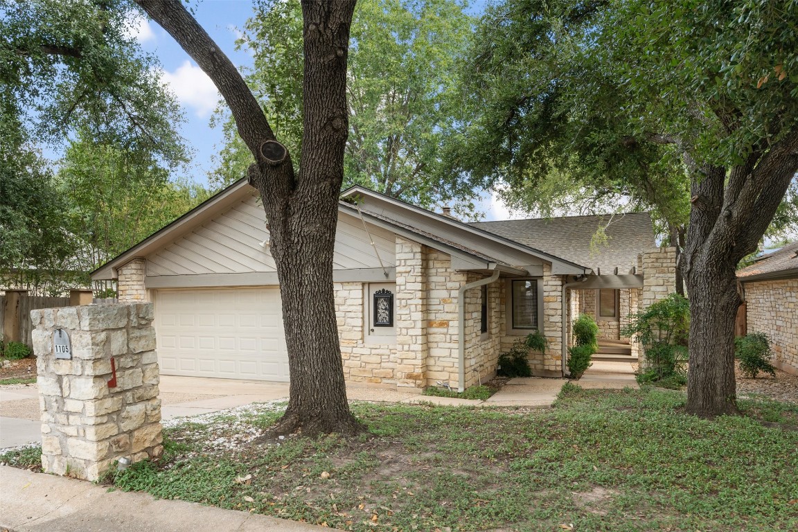 a view of a small house with a tree in the yard