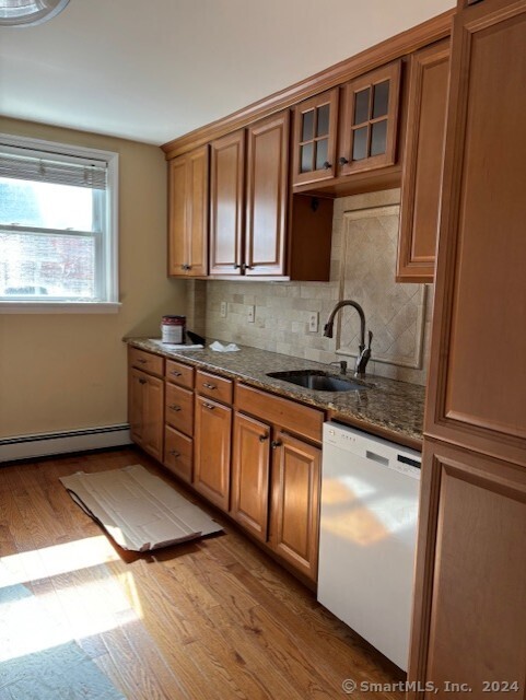 a kitchen with stainless steel appliances granite countertop a sink dishwasher a refrigerator and wooden floor