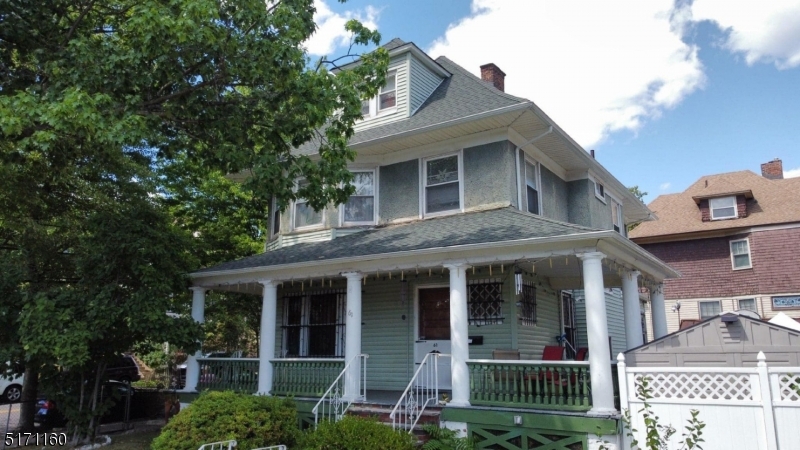 a view of a brick house with a large windows and a large tree