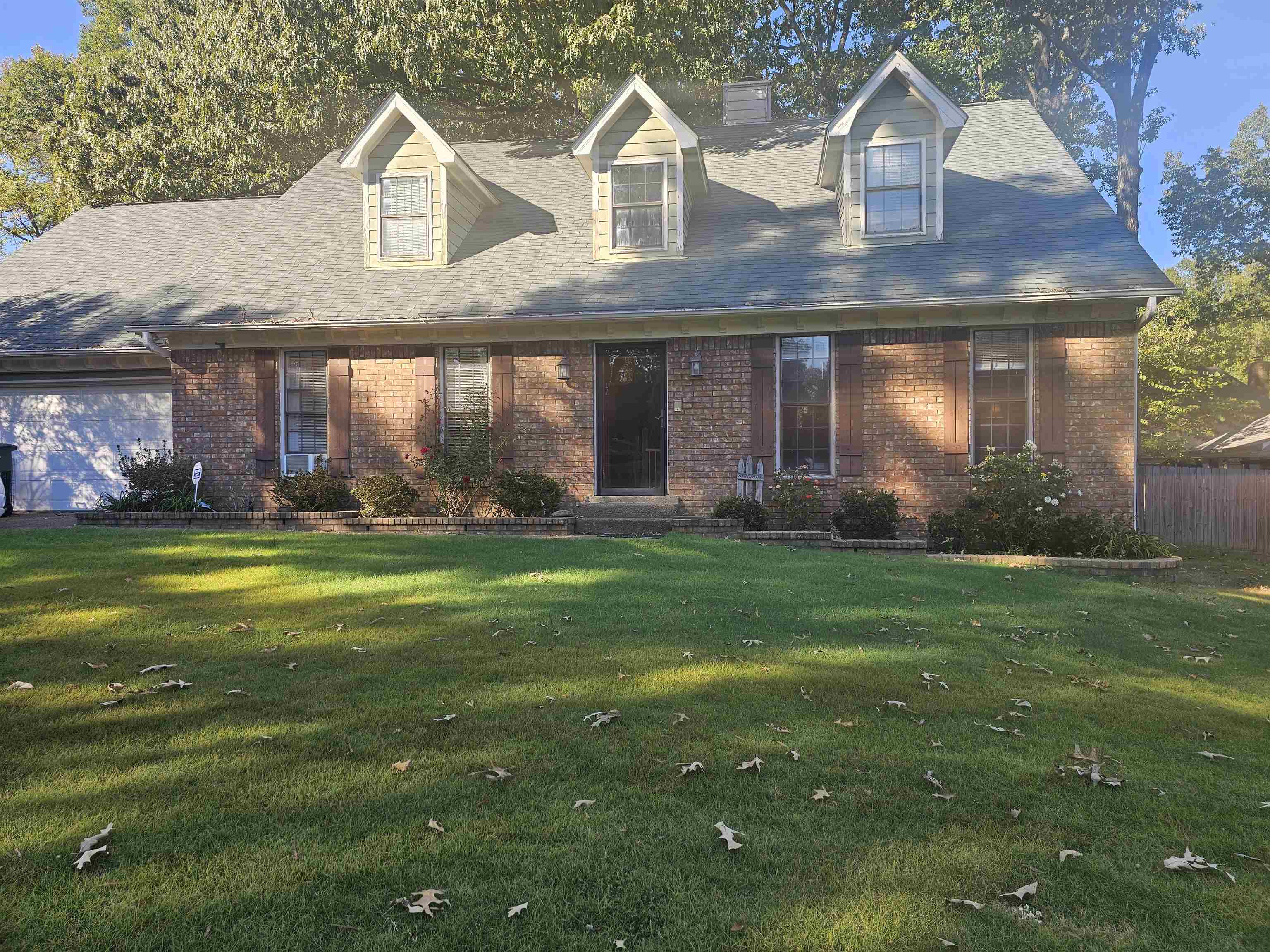 a front view of a house with a garden and yard