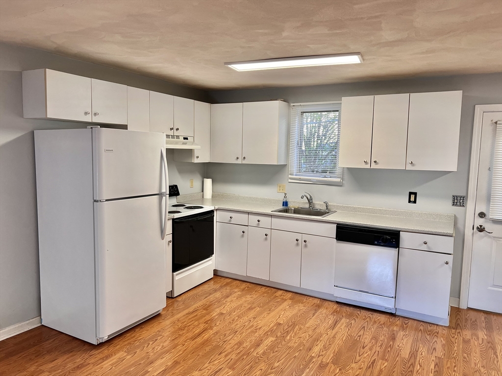 a kitchen with granite countertop white cabinets and white appliances