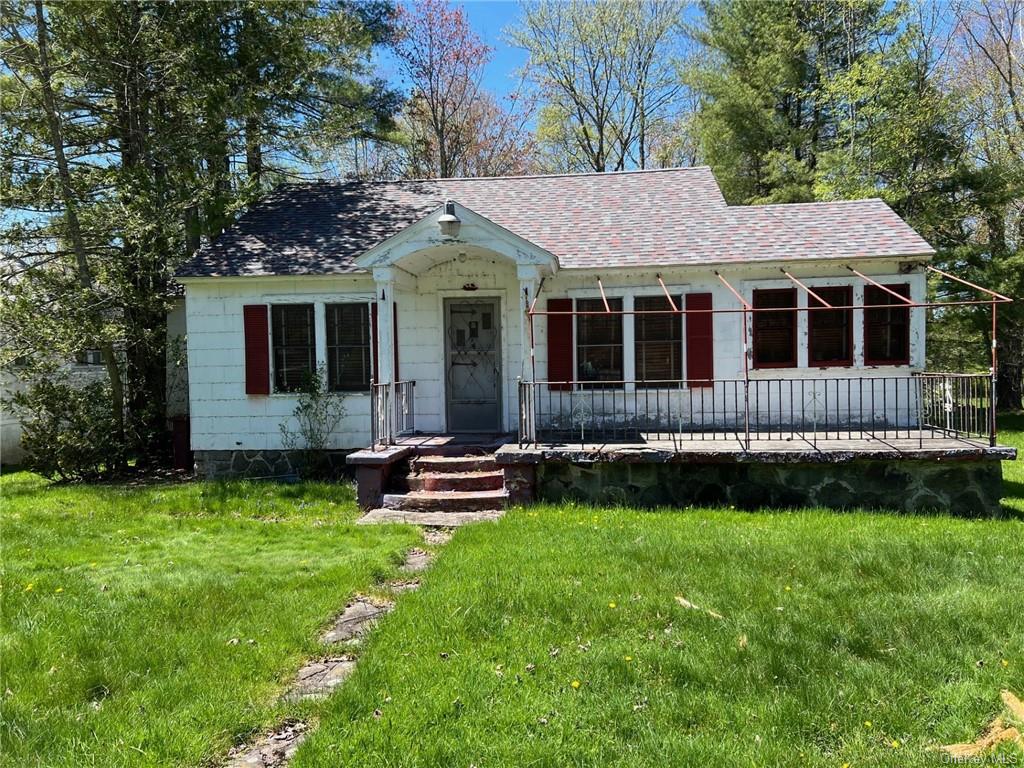 a view of a house with a yard and sitting area