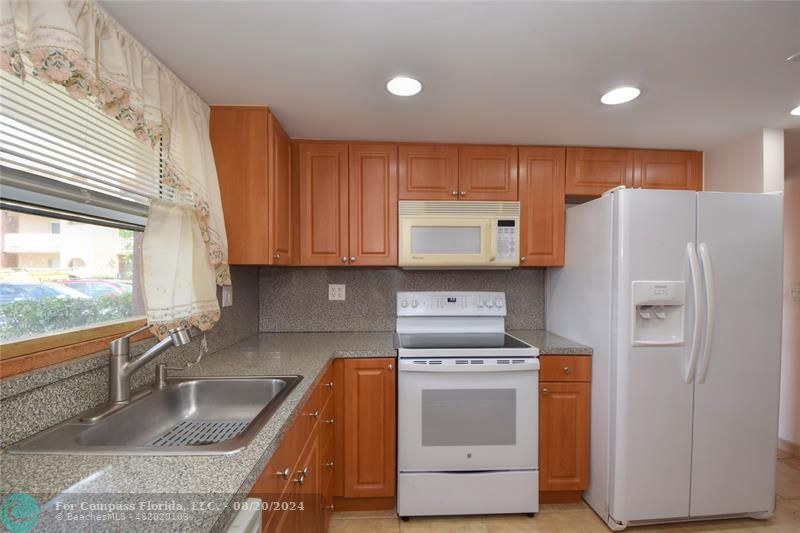 a kitchen with a refrigerator sink and stove